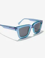 Lentes de sol unisex Hawkers X Casetify modelo One Uptown, con montura cuadrada de acetato color celeste con detalles en azul y lentes grises.