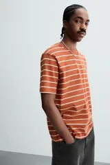 Remera color arena de corte recto, cuello redondo y mangas cortas.