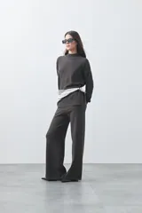 Pantalón de punto de corte relajado, con pierna recta y caída fluida. Presenta cintura con cordón ajustable y diseño minimalista.