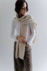 Bufanda de punto suave en color beige, con diseño liso y terminaciones acanaladas en los extremos.