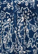 Pantalon de corte recto y tiro medio, confeccionado en tejido de algodón con estampado paisley. Presenta cintura con elástico y bolsillos laterales.