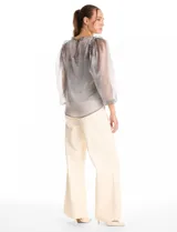 Blusa de organza translúcida con acabado satinado, mangas estilo balloon con volados en los hombros y puños elastizados. Incluye musculosa interna a tono.