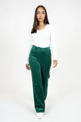 Pantalón de corte recto y tiro alto confeccionado en pana color verde esmeralda. Presenta cintura con trabillas y cinturón del mismo tejido con hebilla forrada, cierre frontal con cremallera y bolsillos laterales.