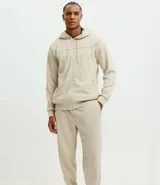 Pantalón deportivo de corte ajustado, confeccionado en tejido de poliéster texturizado color negro. Presenta cintura elástica con cordón de ajuste, bolsillos laterales con cierre y puños elásticos en los tobillos.