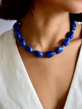 Collar de cuentas ovaladas de resina en color azul intenso, con cadena de ajuste para regular la altura.