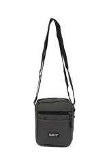 Morral de diseño compacto en color gris oscuro, con cierre principal y bolsillo frontal con cierre. Incluye una etiqueta decorativa con texto en el frente y correa ajustable para llevar al hombro o cruzado.