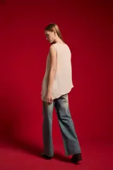 Musculosa de poliéster color natural, sin mangas, con cuello redondo y diseño asimétrico.