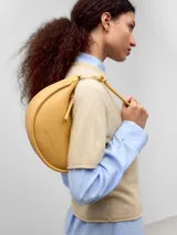 Bolso de hombro mediano color tostado, marca Adolfo Dominguez, con asa corta y cierre de cremallera.