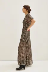 Vestido midi con estampado batik en tonos oscuros y dorados, de escote en V, mangas cortas con vuelo y detalle de fruncido central en la cintura.