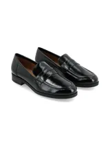 Mocasín de estilo clásico confeccionado en cuero charol negro, con detalle de antifaz en el empeine y suela plana con pequeño tacón.