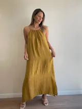 Vestido largo de lino color negro oscuro, con escote fruncido y tirantes finos ajustables. Presenta aberturas laterales en el ruedo.