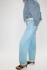 Pantalón de jeans estilo relaxed fit, de tiro alto, color azul con efecto lavado y botamanga con vuelta. Cuenta con cinco bolsillos, trabillas para cinto y cierre frontal con cremallera y botón metálico.