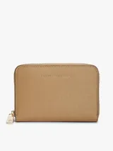 Billetera Tommy Hilfiger de tamaño compacto, color beige con acabado texturizado y cierre de cremallera perimetral con tirador metálico. Cuenta con el logo de la marca en relieve en la parte delantera.