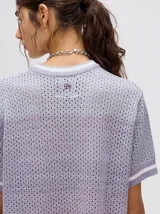 Vestido corto de tejido de punto con efecto degradado, cuello redondo y mangas cortas con puños a rayas en contraste. Presenta un diseño holgado y calado.