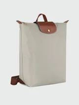 Mochila Longchamp modelo Le Pliage Original tamaño M, de color negro con detalles en cuero marrón y herrajes dorados. Cuenta con solapa con botón a presión, cierre superior y correas ajustables.