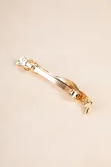 Broche dorado con forma ondulada.