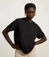 Remera boxy negra de manga corta, confeccionada en algodón BCI, con cuello redondo y sisa deslocada.