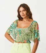 Blusa cropped de tul con estampado de bananas, escote cuadrado, mangas cortas amplias, detalle de látex en el cuerpo y volantes en el bajo.