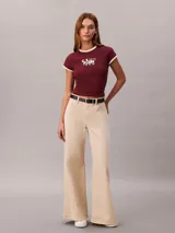 Remera Calvin Klein de color bordó, corte ajustado y manga corta. Presenta cuello redondo y ribetes en las mangas de color blanco en contraste, además de un estampado gráfico en el pecho con el nombre de la marca y el año 1968.