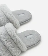 Pantufla cerrada de diseño acolchado con gajos, confeccionada en tejido de textura felpuda suave, con suela de goma termoplástica.