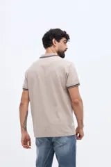 Chomba piqué de manga corta verde militar con cuello y puños tejidos a contratono en tonos claros. Cuenta con cartera de tres botones y pequeño logo bordado en el pecho.