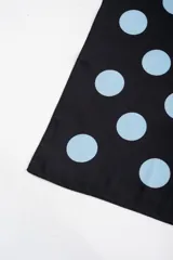 Bandana de poliéster negra con estampado de lunares celestes.