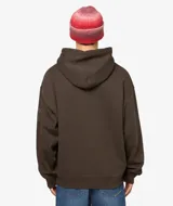 Sudadera con capucha color marrón oscuro, con bordado frontal en hilo claro que simula un diseño abstracto o caligráfico y un detalle bordado en la manga.