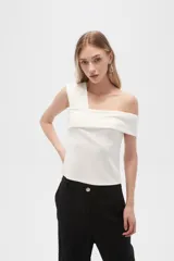 Top blanco de poliéster, al cuerpo, con bretel ancho y cuello asimétrico.