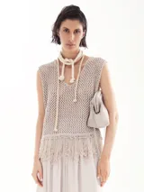 Chaleco de lurex color beige, tejido a crochet, con flecos en el ruedo y escote en V.