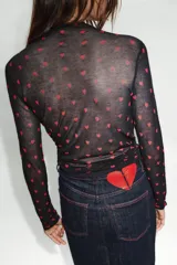 Falda midi de tiro alto confeccionada en denim oscuro, con cinco bolsillos estilo jean, cierre frontal con cremallera y botón, y abertura en la espalda. Presenta pespuntes en color rojo contrastante.