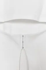 Remera de algodón con cuello redondo y manga corta, que presenta un diseño con aberturas y ganchos metálicos en la espalda.