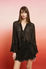Blusa holgada de poliéster con efecto lurex, manga larga con volados en los puños, cuello camisa y cierre frontal anudado.