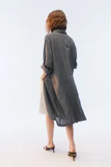 Tapado oversize largo midi, color gris con textura de microcuadrillé, cuello con solapa, cierre frontal con botones, bolsillos con tapa y hombros caídos.