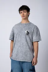Remera de algodón con efecto acid wash en color gris oscuro. Presenta un diseño estampado en el pecho con una estrella amarilla y un personaje animado, y un corte semi-oversize.