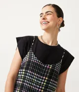 Enterito corto con tirantes finos y estampado a cuadros en tonos blanco, negro, verde y amarillo.