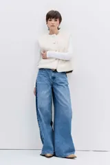 Chaleco reversible de diseño acolchado con costuras en rombos, color tostado con interior de corderito blanco. Presenta cierre frontal con botones, cuello redondo y bolsillos delanteros.