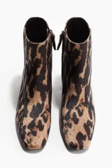 Botines de caña corta con estampado de leopardo, punta de almendra y taco cuadrado. Presentan un forro y plantilla de punto.