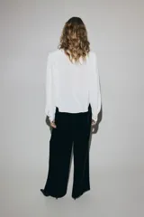 Pantalón de tiro alto de velour negro, de corte recto con pinzas y cintura elástica.