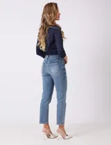 Jean estilo mom slim de tiro alto, con corte relajado en cadera y muslos, y pierna ligeramente entallada hacia el tobillo. Cuenta con pretina con pasadores, cierre frontal con cremallera y botón, y bolsillos funcionales en delantero y trasero.