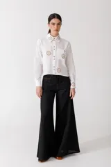 Pantalón de lino blanco de corte wide leg, con diseño amplio y costuras pespunteadas a contratono.