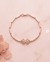 Pulsera de plata con baño de oro rose, con diseño rígido articulado y detalles centrales decorados con circnias pavé.