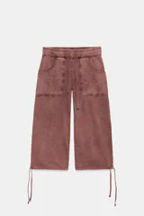 Bermuda larga de algodón con efecto lavado, color bordó, tiro medio y cintura elástica ajustable con cordón. Cuenta con bolsillos de plastrón en el delantero y bajo ajustable con cordones.