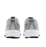 Championes New Balance modelo 740, con estética inspirada en el running de los años 2000. Presentan una parte superior de malla gris con superposiciones sintéticas metalizadas, entresuela blanca con tecnología de amortiguación y suela de goma negra.