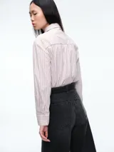 Camisa de corte clásico con estampado de rayas verticales azules y blancas, cuello camisero y cierre frontal con botones. Incluye una corbata a juego con el mismo estampado.