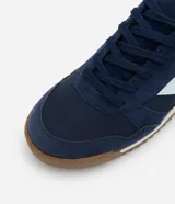 Championes estilo vintage runner color azul marino, con detalles laterales en color celeste claro y suela de goma dentada en tono marrón.