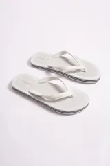 Ojota de hombre marca Mistral, color blanco con detalles de líneas negras en el borde de la suela. Presenta textura rayada en la base y logo de la marca en relieve tanto en la plantilla como en las tiras.