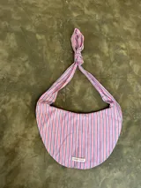 Bolso hobo de tela rayada rosa y azul con asa superior anudada.