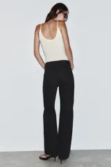 Jeans de tiro alto, pernera recta y larga, estilo clásico con cinco bolsillos, cierre frontal con cremallera y botón metálico.