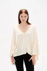 Poncho negro de tejido de punto con escote en V, diseño asimétrico y corte holgado.