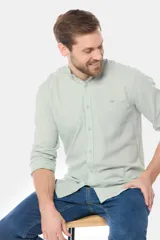 Camisa de lino color verde claro, con cuello mao, manga larga y botones personalizados.